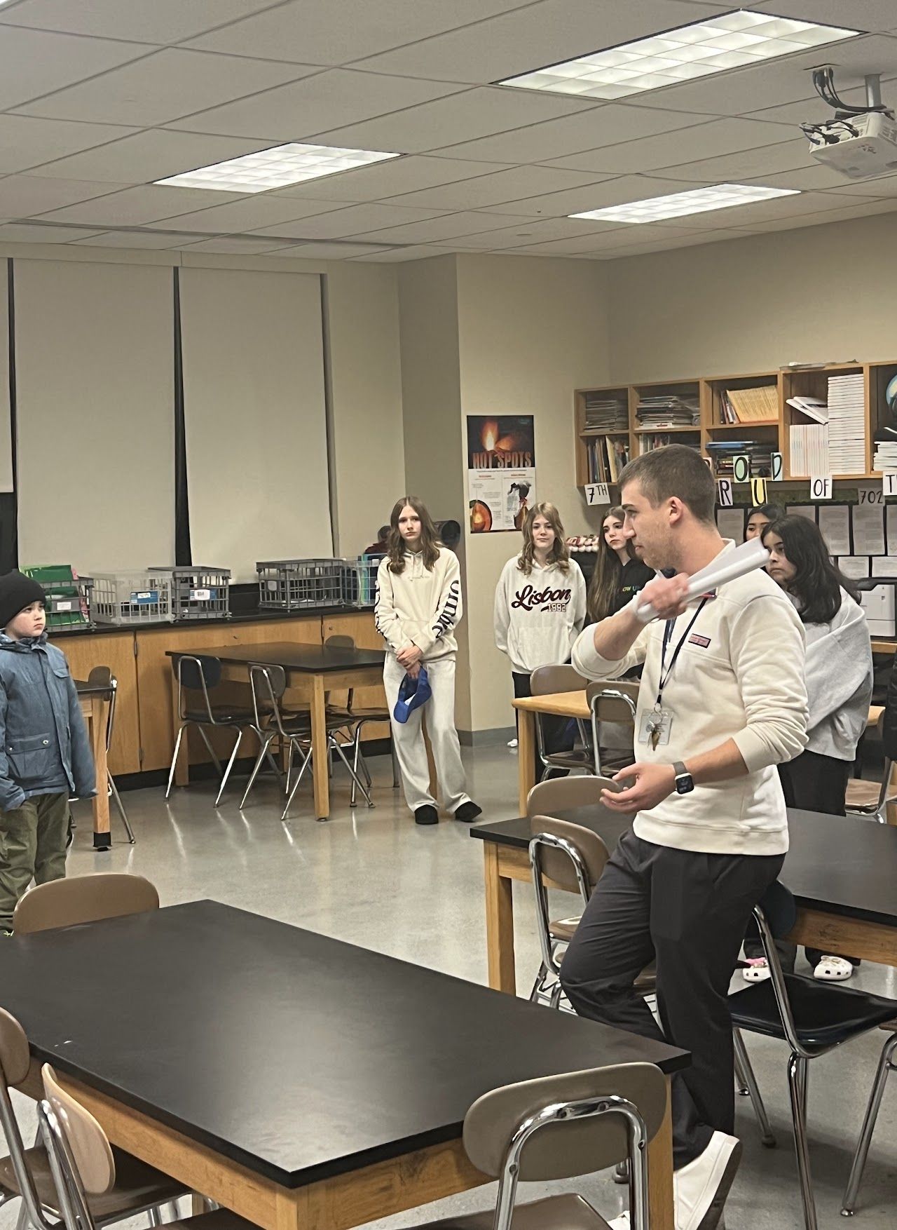 A presenter speaks to students and families in a science classroom.